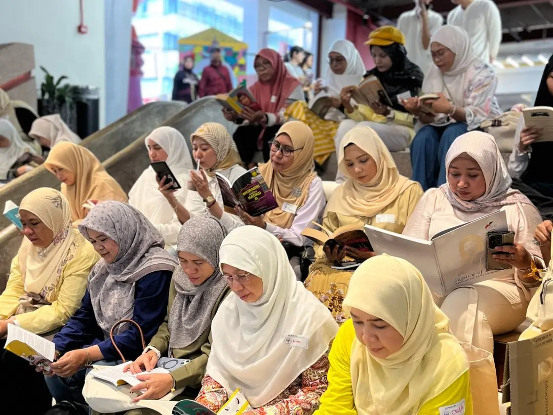 Sekumpulan perempuan duduk berbaris sambil membaca buku masing-masing pada satu pertemuan Kelab Perempuan Membaca.